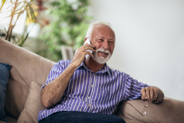 Ein Senior telefoniert mit der Pflegekasse